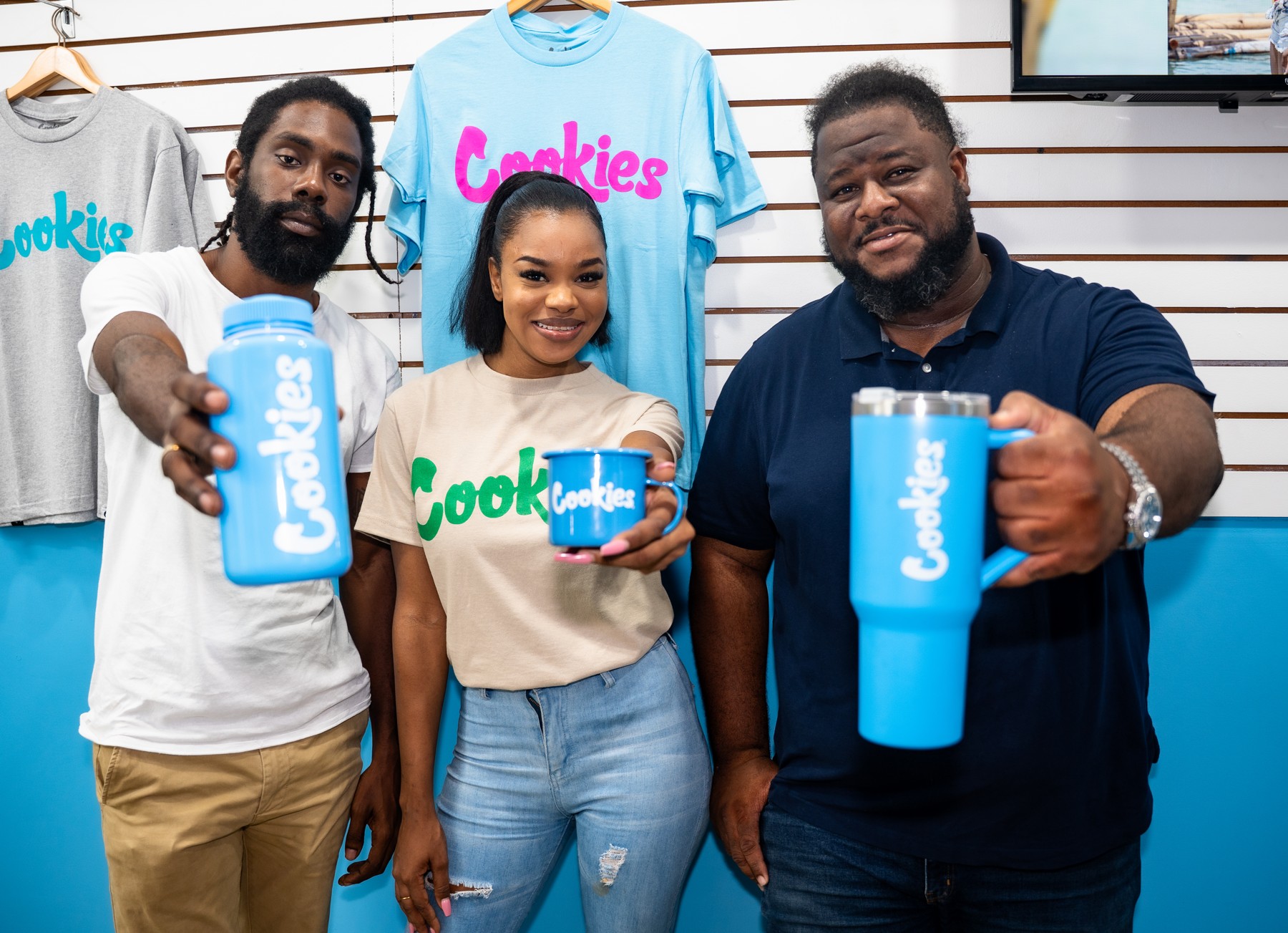 Three people smiling and holding blue Cookies tumblers